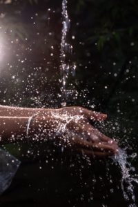 human hand under pouring water